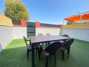 a black table and chairs on a green lawn at People Homes Bajo Guía in Sanlúcar de Barrameda