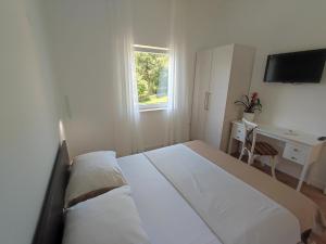 a bedroom with a bed and a desk and a window at Apartman Vlatka 