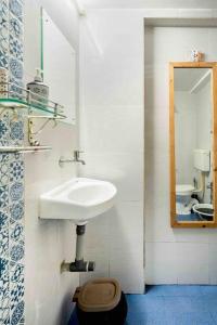 La salle de bains est pourvue d'un lavabo et d'un miroir. dans l'établissement The Burrow in South Goa., à Dabolim