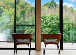 two chairs in a room with a view of a waterfall at and RIVER KATSUURA in Katsuura