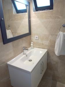 a bathroom with a white sink and a mirror at Stonehouse Aparts Dublex 3+1 mit Meerblick und Jakuzzi Kalkan No:5 in Kalkan