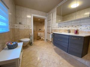 een grote badkamer met een wastafel en een toilet bij Ferienhaus Römer in Wirft