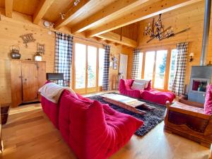 a living room with red couches and a tv at La Pourvoirie - 4 Vallées - Thyon-Les Collons, 10 personnes, pistes de ski à 200m, magnifique vue in Hérémence