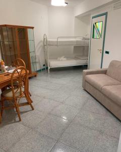 - un salon avec un canapé, une table et des lits superposés dans l'établissement Leto House Apartments, à Letojanni