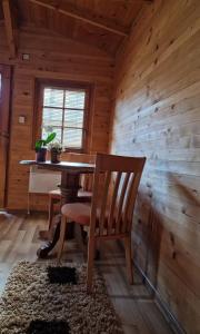 a wooden dining room with a table and a chair at Bungalovi Menzil in Zavidovići