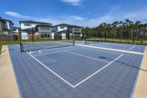 a tennis court in front of some houses at Modern Luxury 4BR Pool Bay Access Outdoor Dining in Pensacola