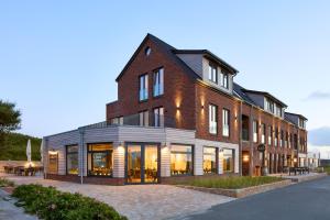 a large brick building with windows on a street at Westeroog in Wangerooge
