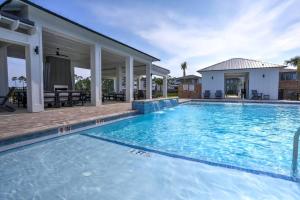 a swimming pool in front of a house at Modern Luxury 4BR Pool Bay Access Outdoor Dining in Pensacola