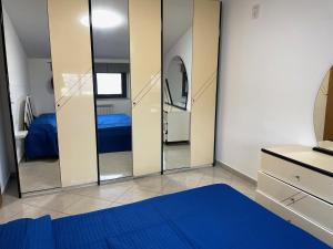 a bedroom with two mirrors and a blue bed at IL SOGNO DEL MARE in Montesilvano