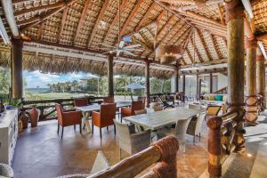 une salle à manger avec des tables et des chaises dans un complexe dans l'établissement 5BR Cap Cana Villa with Ocean & Golf Views, Chef, Maid, Butler, Pool, Jacuzzi, and Beach Club Access, à Punta Cana