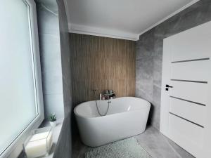 uma banheira branca na casa de banho com uma janela em Sunset House spacious 3 bedrooms Baciu Cluj em Baciu