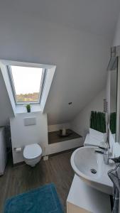 ein Bad mit einem WC und einem Waschbecken mit einem Fenster in der Unterkunft Helle Wohnung mit zwei Schlafzimmern in Eching