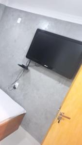 TV de pantalla plana en la parte superior de una mesa en Pousada GPC en Macaé