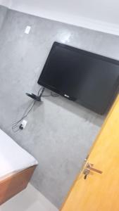 uma televisão de ecrã plano em cima de uma mesa em Pousada GPC em Macaé