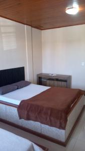 a bedroom with a large bed and a desk at Pousada GPC in Macaé