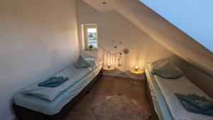 two beds in a small room with two lamps at Helle Wohnung mit zwei Schlafzimmern in Eching