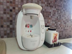 a white mixer sitting on a counter next to a coffee maker at Little pomegranate apartment in Kapótidhes