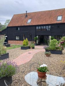 a house with a glass table in front of it at Bluebell Barn in Banham