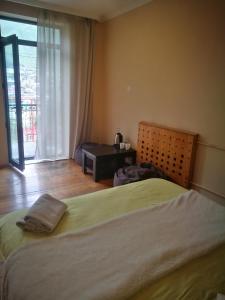 a bedroom with a bed and a room with a window at Belas guesthouse in Stepantsminda