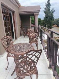 波羅克瓦尼的住宿－Lady D Exclusive Abode，阳台配有3把椅子和1张桌子
