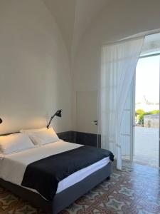 a bedroom with a bed and a large window at Masseria Monè in Monopoli