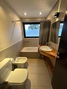 a bathroom with a toilet and a tub and a sink at TERRAZAS DEL MASCARDI - LUXURY APARTMENT - INMEJORABLE UBICACION in San Martín de los Andes