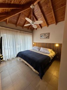 Schlafzimmer mit einem Bett und einem Deckenventilator in der Unterkunft TERRAZAS DEL MASCARDI - LUXURY APARTMENT - INMEJORABLE UBICACION in San Martín de los Andes