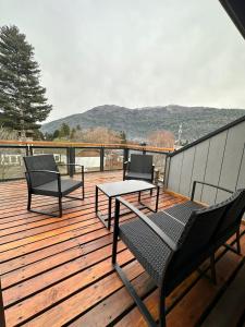 a deck with two chairs and a table on it at TERRAZAS DEL MASCARDI - LUXURY APARTMENT - INMEJORABLE UBICACION in San Martín de los Andes