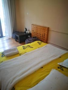 a bedroom with two beds with yellow sheets at Belas guesthouse in Stepantsminda
