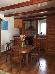 a kitchen with a wooden table and chairs at Gite Les Glycines 4 à 5 Personnes du samedi au samedi in Plonéour-Lanvern