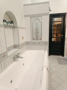 Riverside Old Town Spacious One Bedroom Apartment في ريغا: حمام مع حوض استحمام أبيض وباب أسود