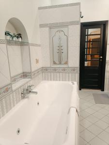 a bathroom with a white tub and a black door at Riverside Old Town Spacious One Bedroom Apartment few steps from Dome square and Cathedral in Rīga +42 photos