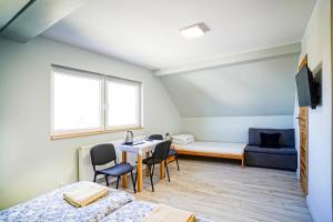 a room with a table and chairs and a couch at Willa Kwiatowa in Iwonicz-Zdrój