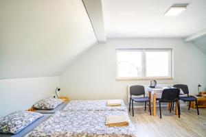 a room with two beds and a table and chairs at Willa Kwiatowa in Iwonicz-Zdrój