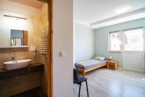 a bathroom with a sink and a bed in a room at Willa Kwiatowa in Iwonicz-Zdrój