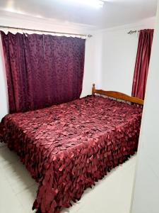 sypialnia z łóżkiem z czerwonym kocem w obiekcie Town Centre Stays w mieście Nadi