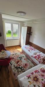 a bedroom with two beds and a table and a rug at Privat Agnesa in Zuberec