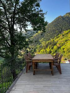 un tavolo in legno e sedie su un patio con vista di كوخ في أوزنغول Uzungöl a Çaykara