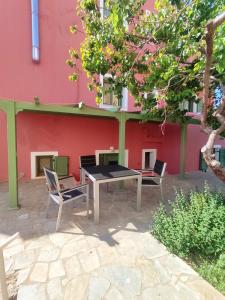 a table and chairs in front of a building at Little pomegranate apartment in Kapótidhes