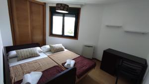 1 dormitorio con 1 cama, TV y ventana en Apartamento terra1, en Caldas de Reis