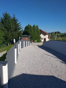 una entrada con una valla blanca y una casa en Apartma Lara, en Lesično