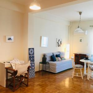 een woonkamer met een bed en een tafel bij BLUE AND WHITE PAINTERS HOUSE in Athene