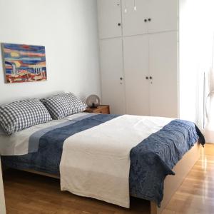 a bedroom with a bed and a painting on the wall at BLUE AND WHITE PAINTERS HOUSE in Athens