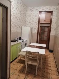 a kitchen with a table and a refrigerator at Ланжероновская угол Дерибасовская in Odesa