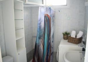 Łazienka z zasłoną prysznicową obok umywalki w obiekcie Lemon House w mieście Neo Klima