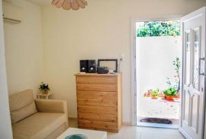 a living room with a chair and a dresser and a door at Lemon House in Neo Klima