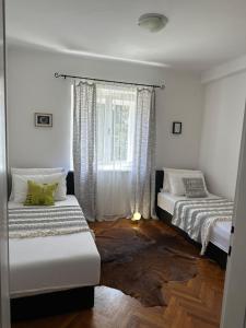 two beds in a room with a window at Cosy Family Apartment Marina Kastela near Airport in Kaštela