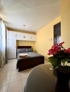 Un dormitorio con una cama y una mesa con un jarrón de flores en House to rent in a Gated Community with 24hr Security, 