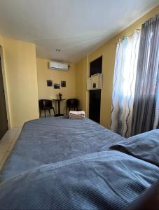 a bedroom with a bed and a table with chairs at House to rent in a Gated Community with 24hr Security in Lawa-an