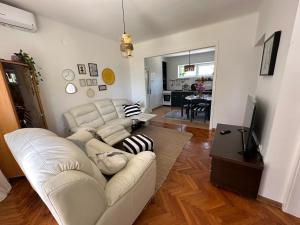 a living room with a white couch and a television at Cosy Family Apartment Marina Kastela near Airport in Kaštela